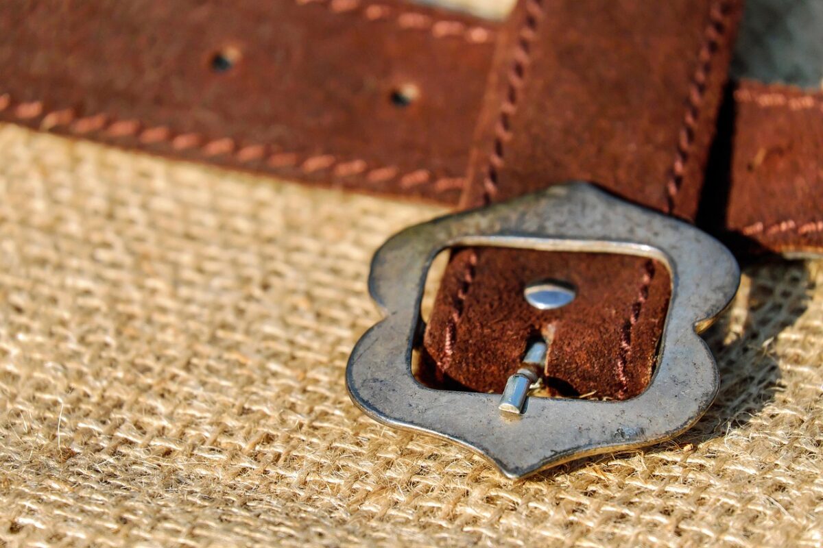 A leather tool belt hanging on a workshop wall